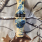 Double reed duck call made from stabilized and dyed yellow cedar burl wood and cocobolo tone board